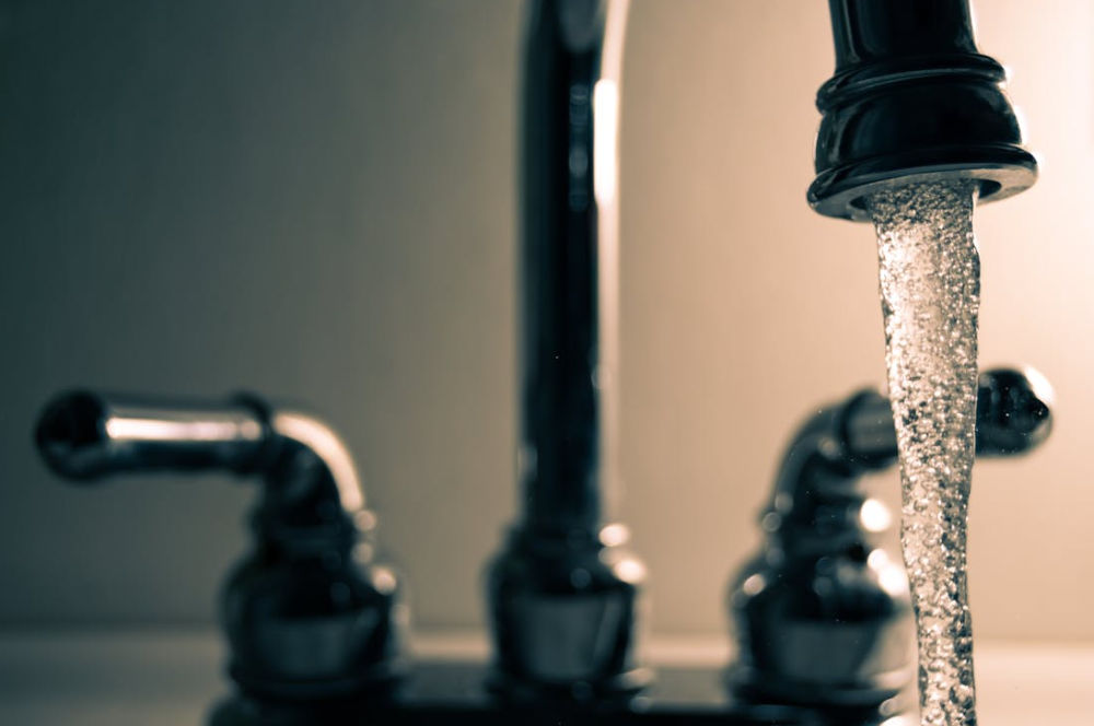 Plumber in Indianapolis, Indiana fixing pipes under a sink, representing the importance of reliable local web hosting for plumbing businesses