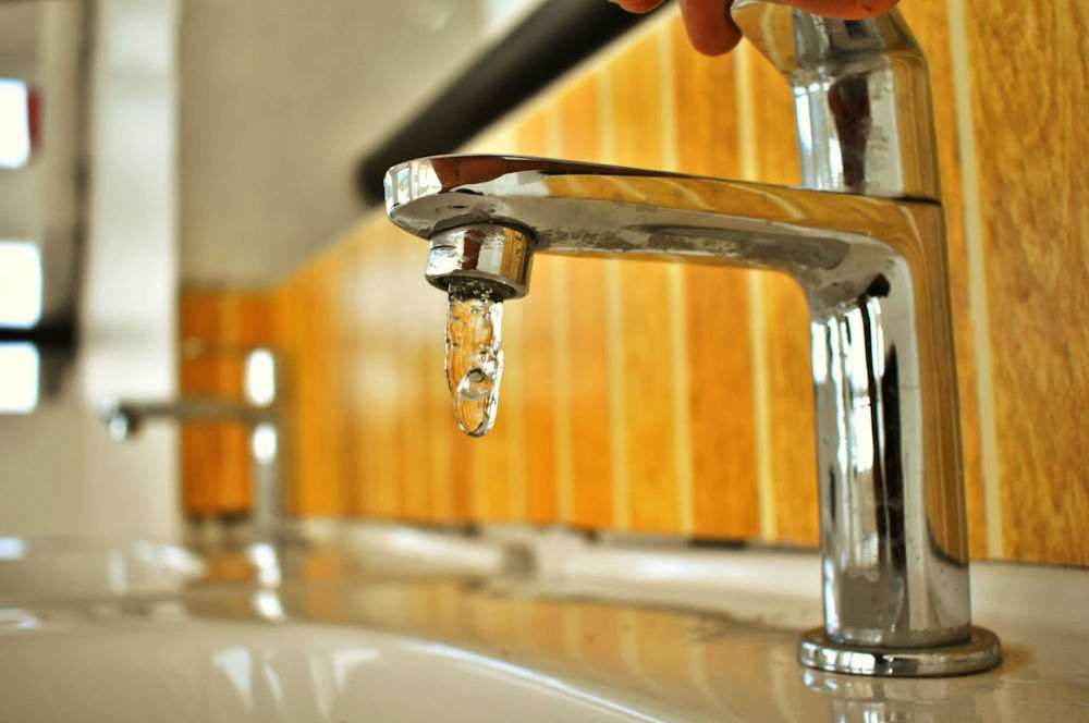 Plumber in Columbus, Ohio working under a sink, symbolizing the importance of reliable local web hosting for plumbing companies